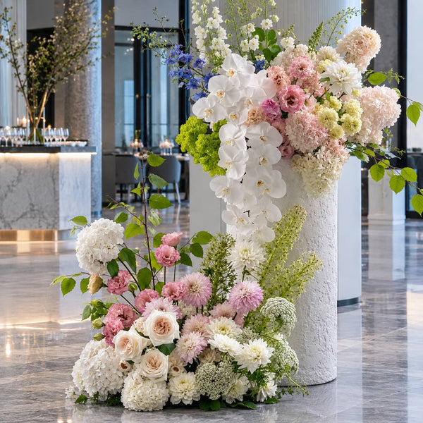 Blush and orchid pedestal arrangement in hotel lobby, Los Angeles