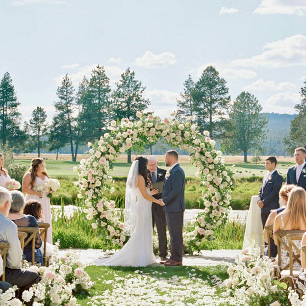Blush and white circle moon wedding arch with roses and greenery at an outdoor ceremony in Los Angeles