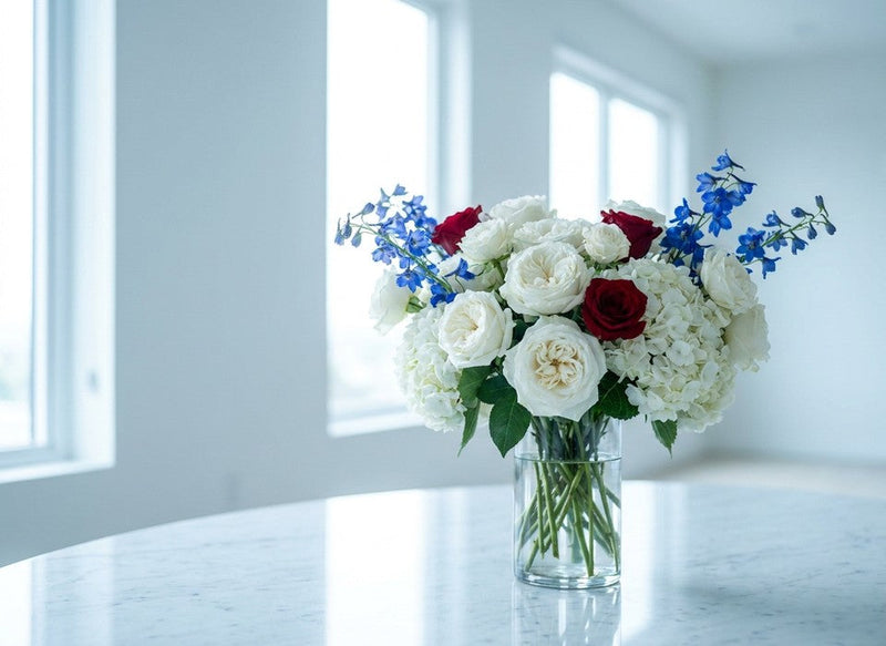 elegant 4th of July red, white and blue rose and delphinium arrangement on a marble table in Los Angeles