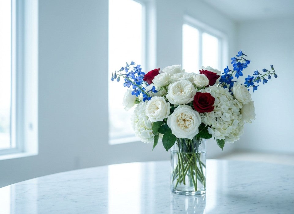 elegant 4th of July red, white and blue rose and delphinium arrangement on a marble table in Los Angeles