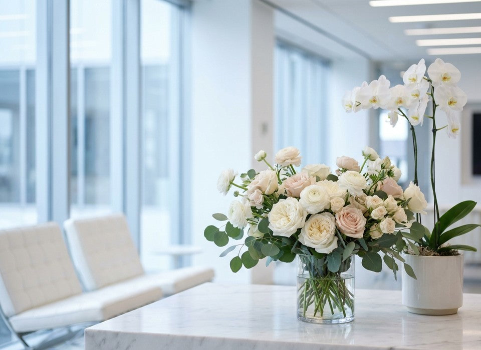 fresh roses and a white orchid plant together on a marble office desk in Los Angeles