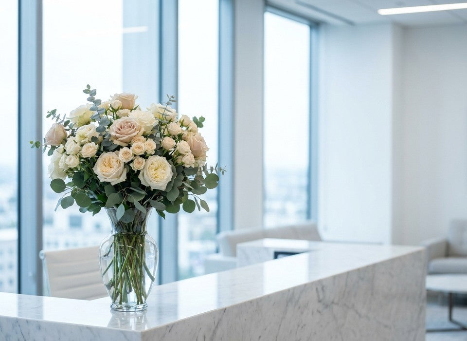 fresh white and blush rose arrangement on a marble office reception desk in Los Angeles