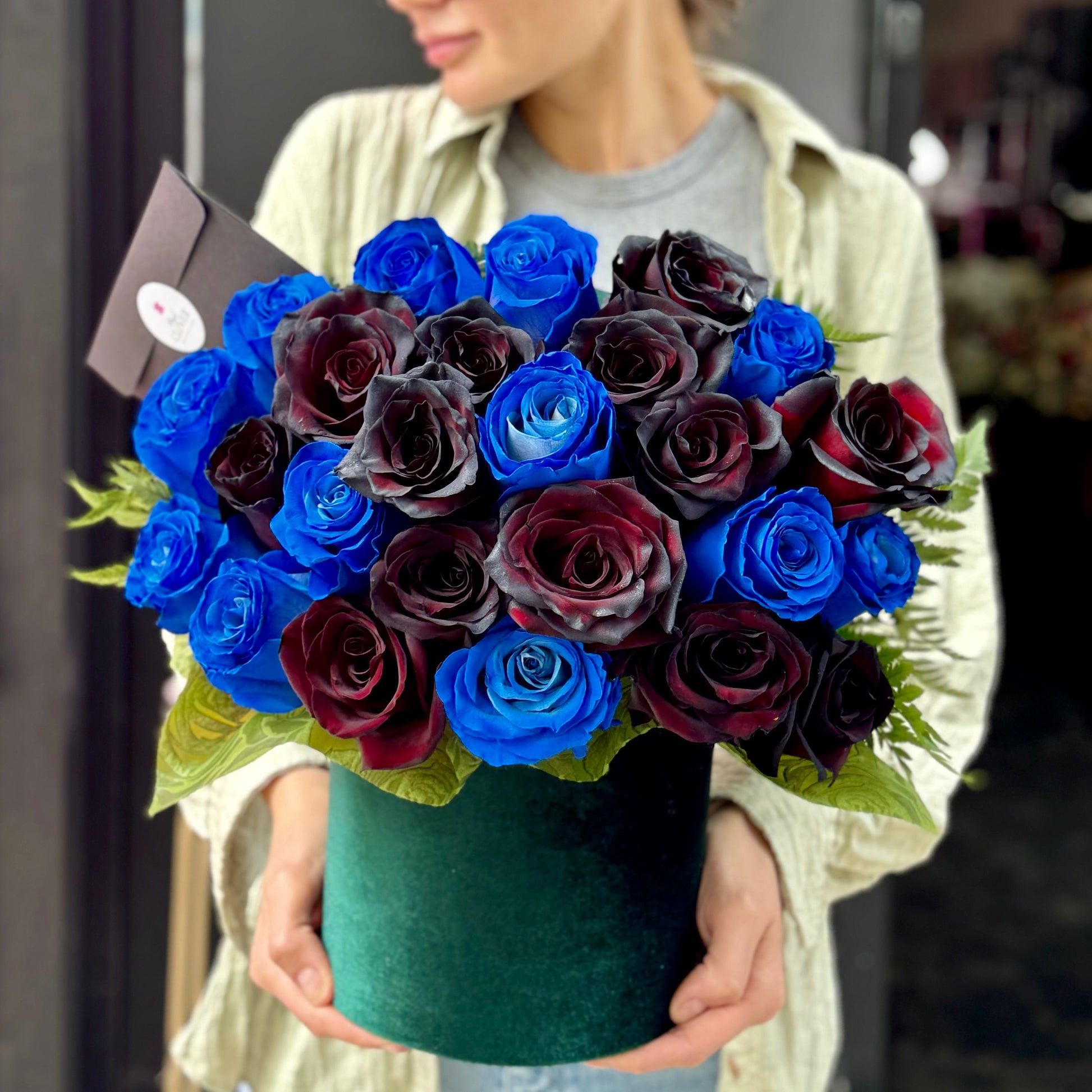 Close-up of deep red roses and ivory lilies intertwined with eucalyptus in a hand-tied bouquet, emphasizing texture and color contrast.