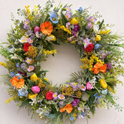 Pink Clover vibrant spring wreath with colorful tulips, poppies, mimosa, and roses for Wreath Subscription Los Angeles.