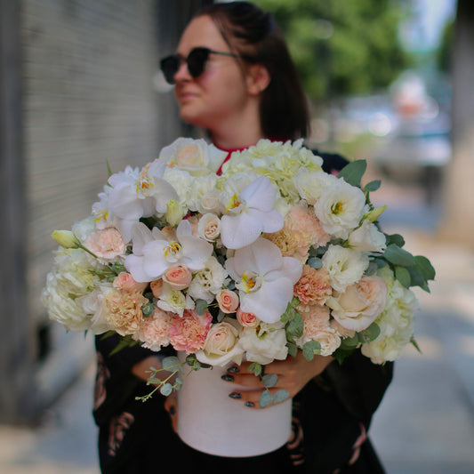 Elegant Cora bouquet featuring beige orchids, garden roses and hydrangeas in a decorative keepsake box – ideal for premium floral delivery