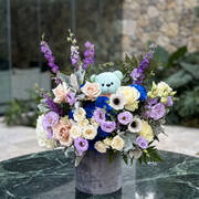 Babyblossom: Pink Clover's lush blue teddy bear arrangement with peach, cream, blue roses, purple lis