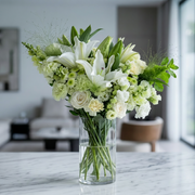 Lush white lilies, roses, and mixed green flowers in an elegant bouquet by Pink Clover, Los Angeles.
