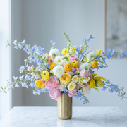 Pink Clover's vibrant spring bouquet: pink roses, yellow ranunculus, blue delphinium, white mums, Los