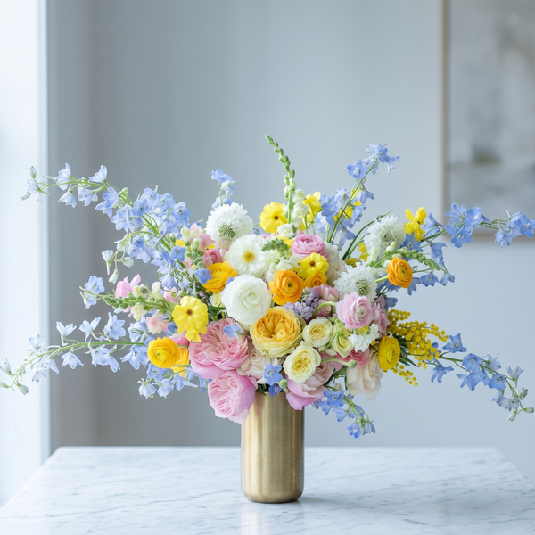 Pink Clover's vibrant spring bouquet: pink roses, yellow ranunculus, blue delphinium, white mums, Los