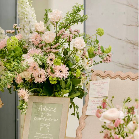 Baby shower advice for the parents floral sign display with blush scabiosa, ivory garden roses, white delphinium, and green viburnum for Los Angeles delivery.