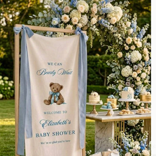 Boy baby shower with tall blue and white floral arch, ivory garden roses, blue hydrangea, delphinium, and We Can Bearly Wait teddy bear sign for Los Angeles delivery.