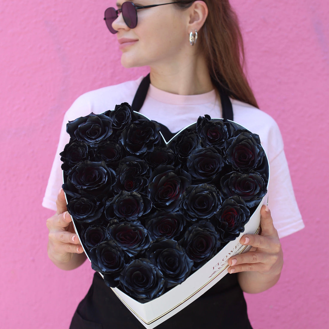 Luxurious heart-shaped box of 25 black roses with gold accents, ideal for dramatic romance