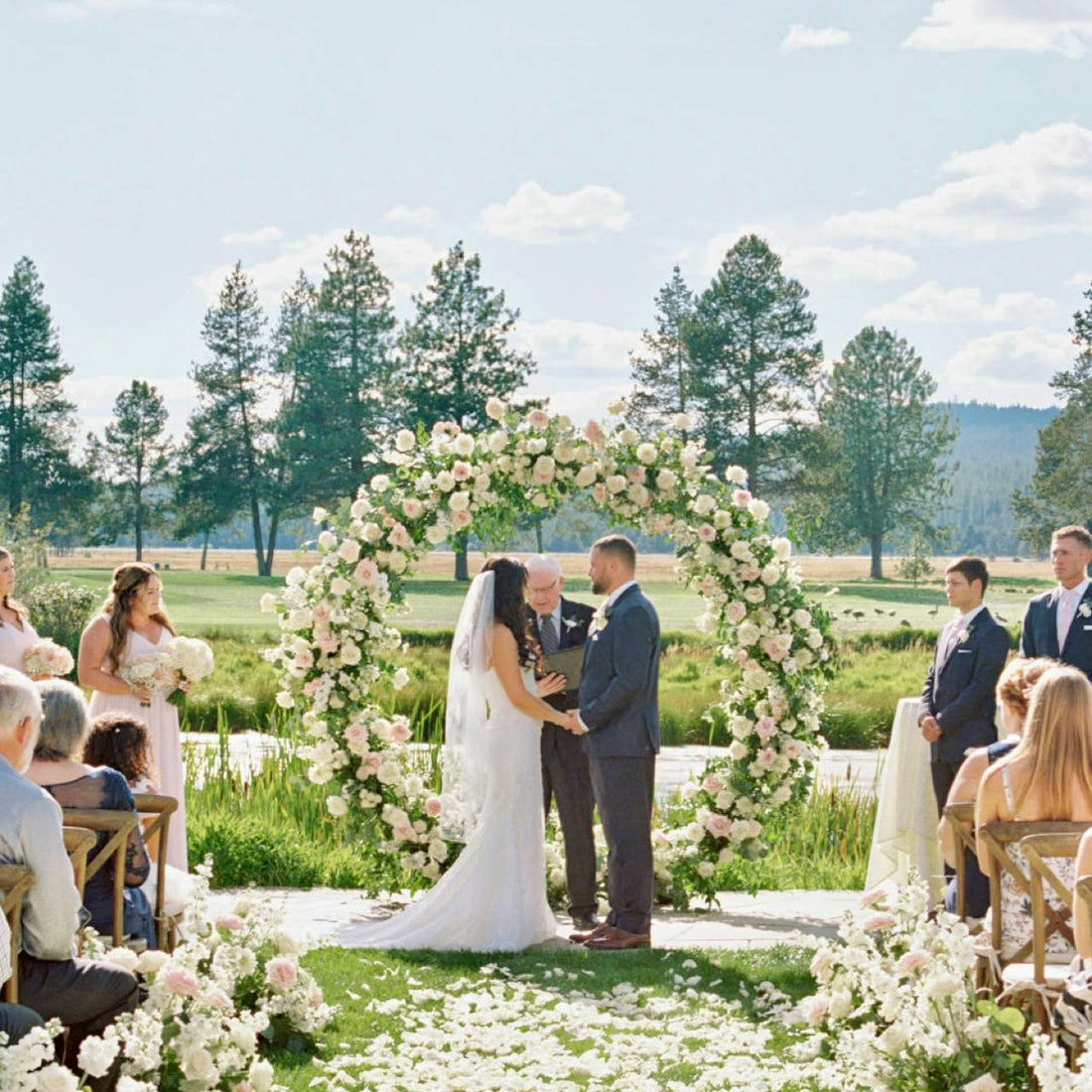 Blush and white circle moon wedding arch with roses and greenery at an outdoor ceremony in Los Angeles
