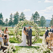 Blush and white circle moon wedding arch with roses and greenery at an outdoor ceremony in Los Angeles