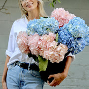 Elegant pink and blue hydrangea bouquet in a glass vase, beautifully styled for luxury floral delivery