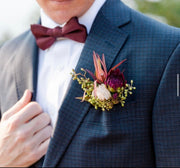 Elegant boutonniere featuring fresh roses and greenery, styled for weddings and formal occasions