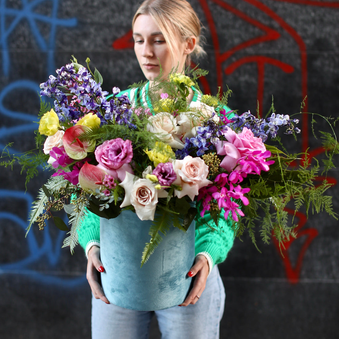 Bright floral arrangement featuring sunflowers, roses and carnations in a colorful keepsake box, styled for cheerful gifting