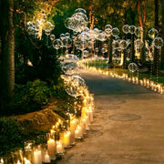 Outdoor garden pathway with clear bubble balloons and pillar candles in glass holders creating cinematic glow for Los Angeles proposal.