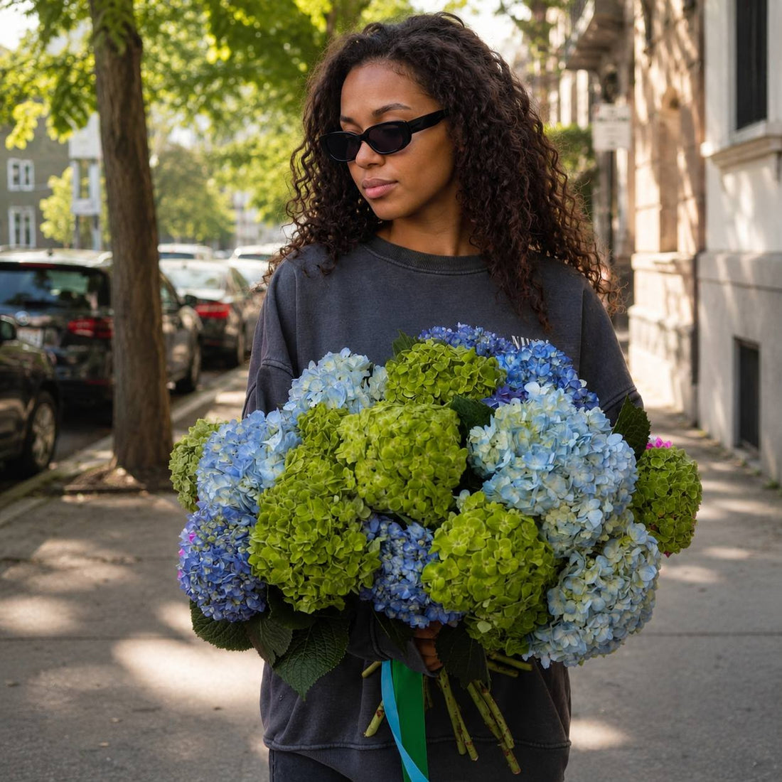 Crystal Lagoon blue and green hydrangea bouquet held on a Los Angeles street — Pink Clover