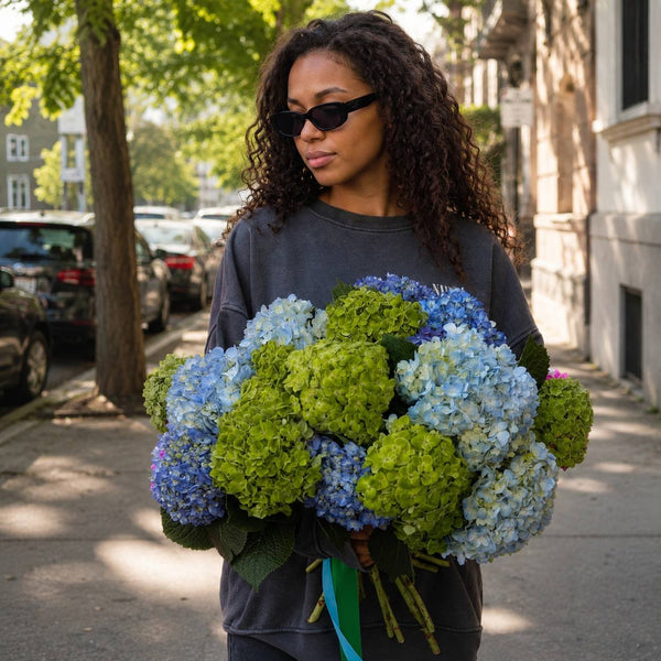 Crystal Lagoon blue and green hydrangea bouquet held on a Los Angeles street — Pink Clover