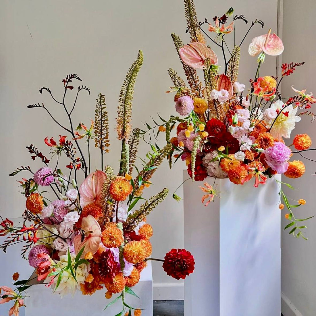 Luxury dahlia and anthurium pedestal arrangements for events in sunset tones by Pink Clover Flowers Los Angeles