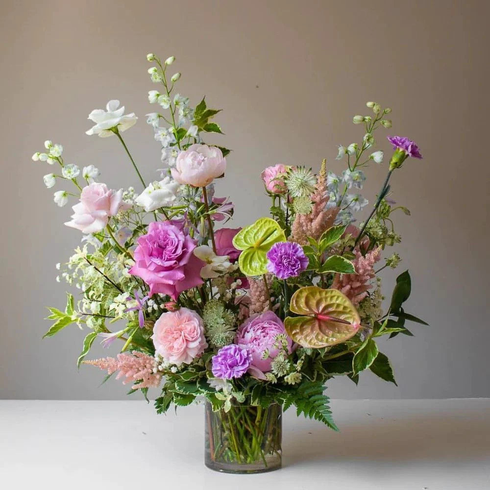 Pink Clover Designer Choice: Lush pink, magenta, purple, green garden-style arrangement with peonies, roses