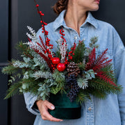 Frosty Cheer Christmas arrangement with red berries, pine and apples in a green box, delivered in Lo
