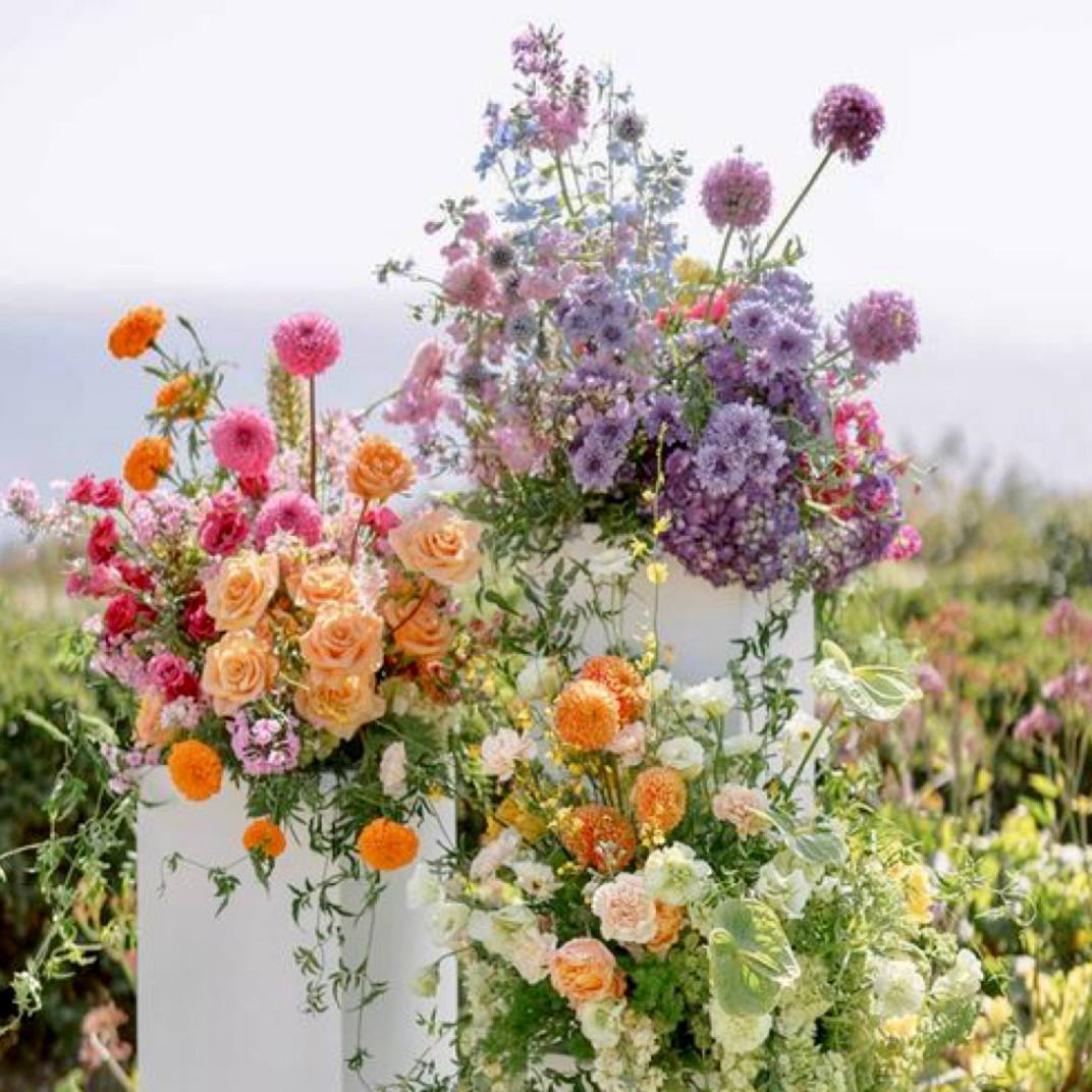 Garden romance pedestal flower collection with peach roses and lavender blooms for outdoor events by Pink Clover Flowers Los Angeles