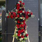 Elegant floral cross arrangement with white blooms, symbolizing peace and reverence