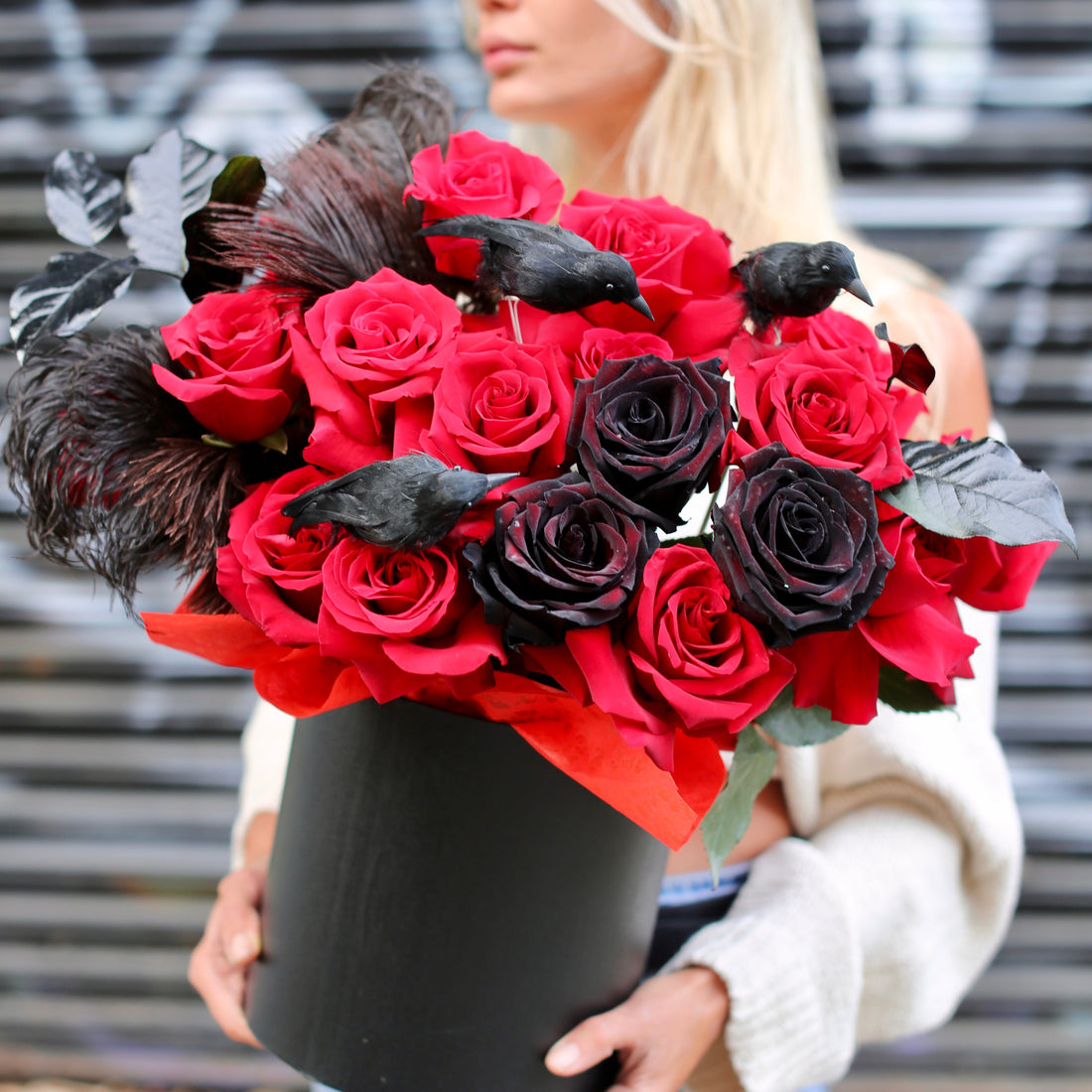 Dramatic Halloween bouquet featuring deep red roses, black accents, and raven decor in a luxury keepsake box