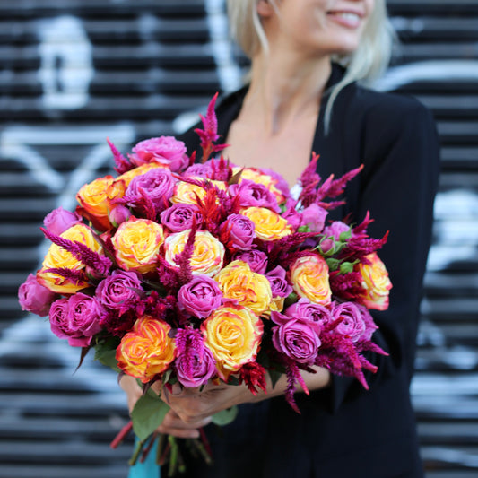 Vibrant Sunset Bliss bouquet featuring purple and yellow roses, beautifully styled for luxury floral delivery and romantic occasions