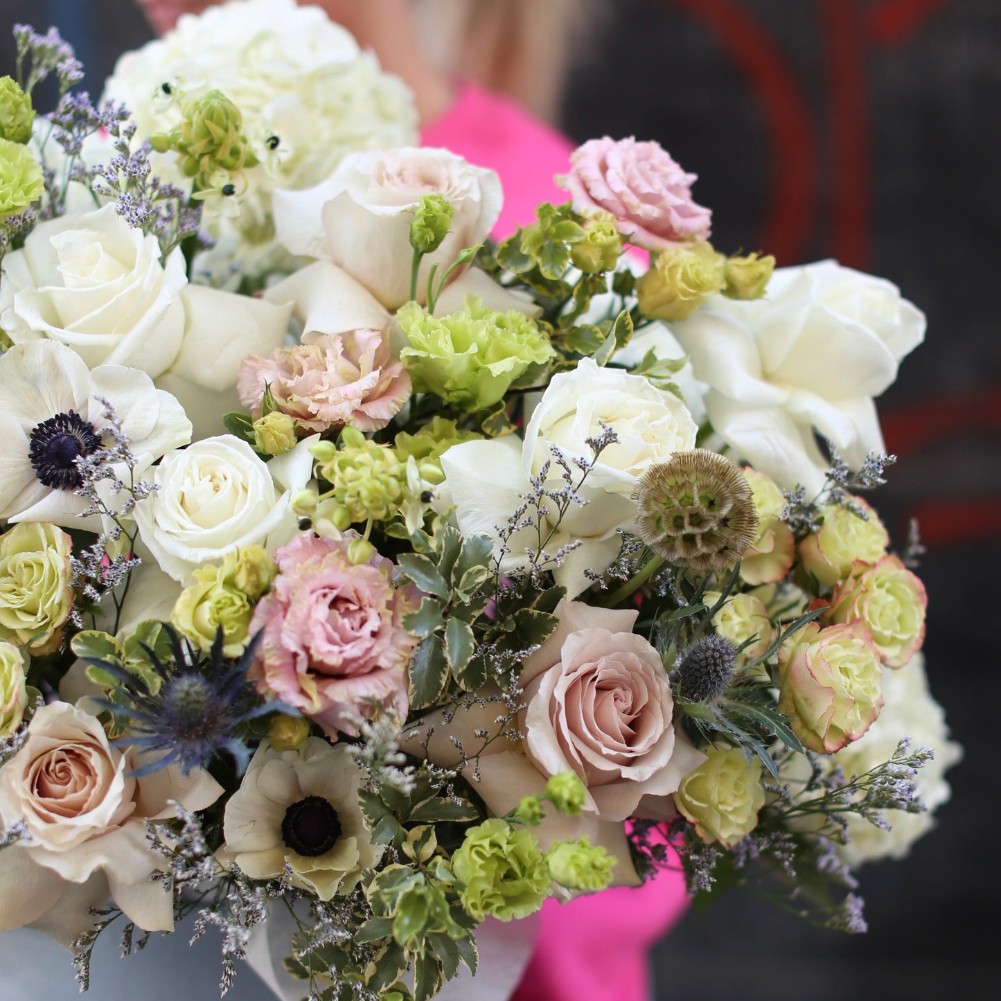 Premium floral gift with bold anemones and soft pink roses arranged in a chic keepsake box