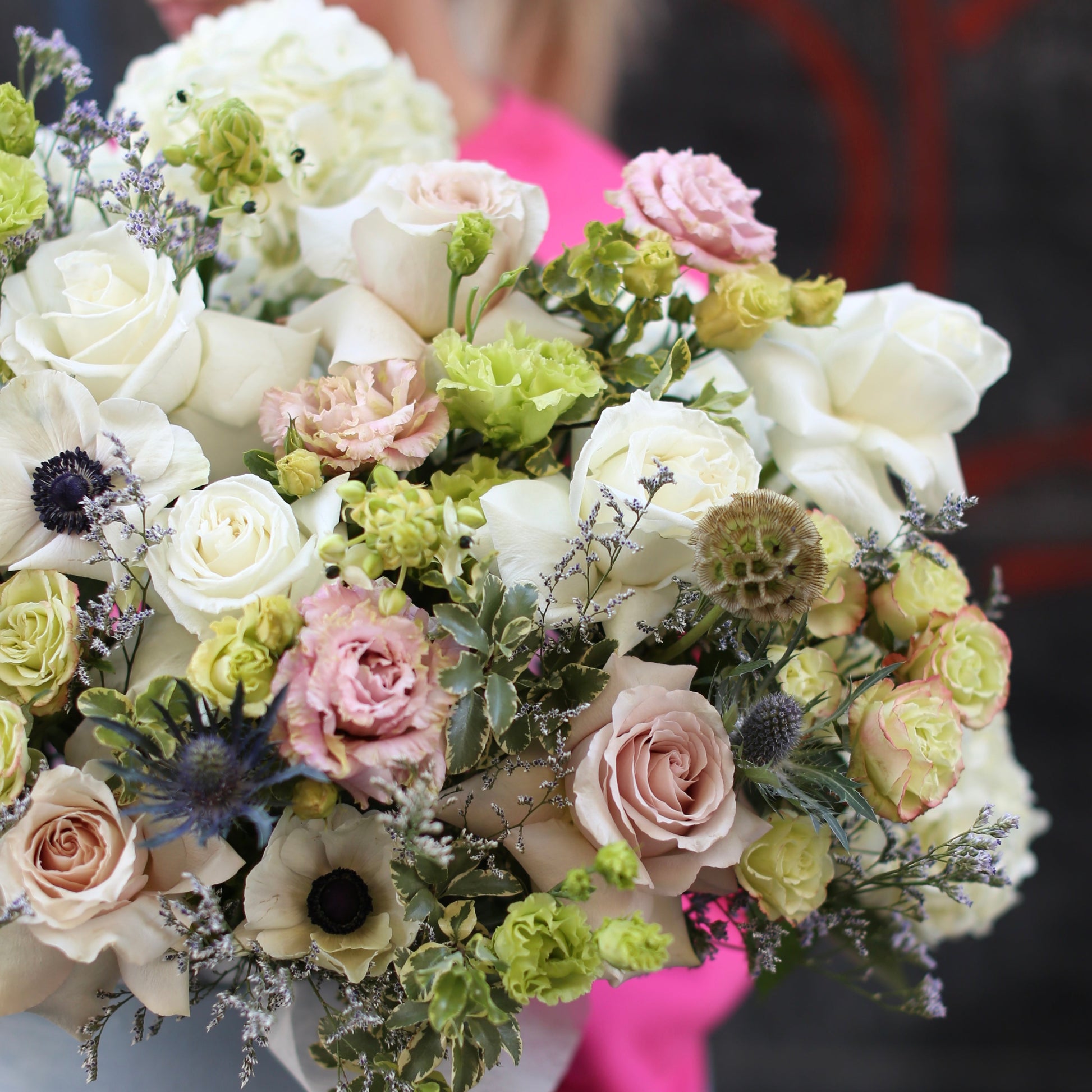 Premium floral gift with bold anemones and soft pink roses arranged in a chic keepsake box