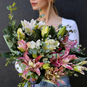Elegant white lilies bouquet with roses and greenery, beautifully wrapped for a premium gifting experience