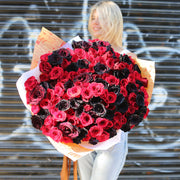 Dramatic Midnight Temptation bouquet with 150 red and black roses, beautifully arranged for luxury floral gifting
