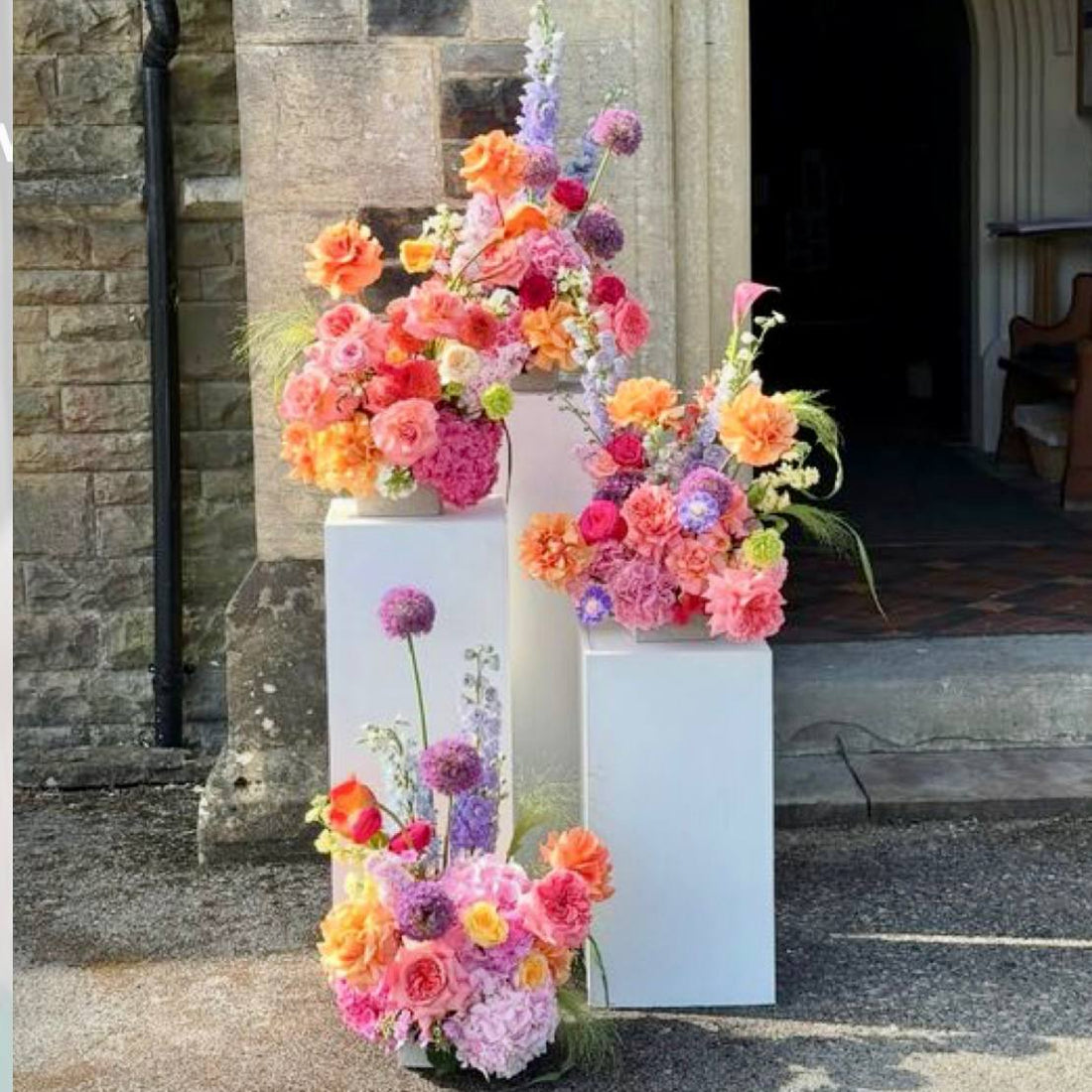 Pastel cascade floral pedestal trio with roses dahlias and allium for luxury events by Pink Clover Flowers Los Angeles