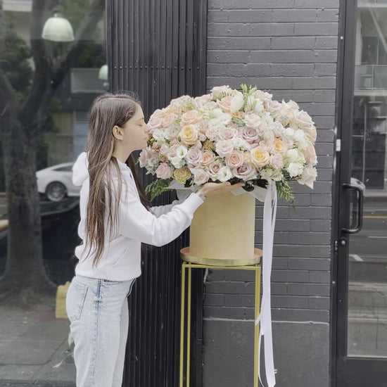 Soft pastel floral arrangement in warm peach and ivory tones, ideal for romantic occasions and special celebrations.