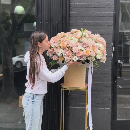 Soft pastel floral arrangement in warm peach and ivory tones, ideal for romantic occasions and special celebrations.