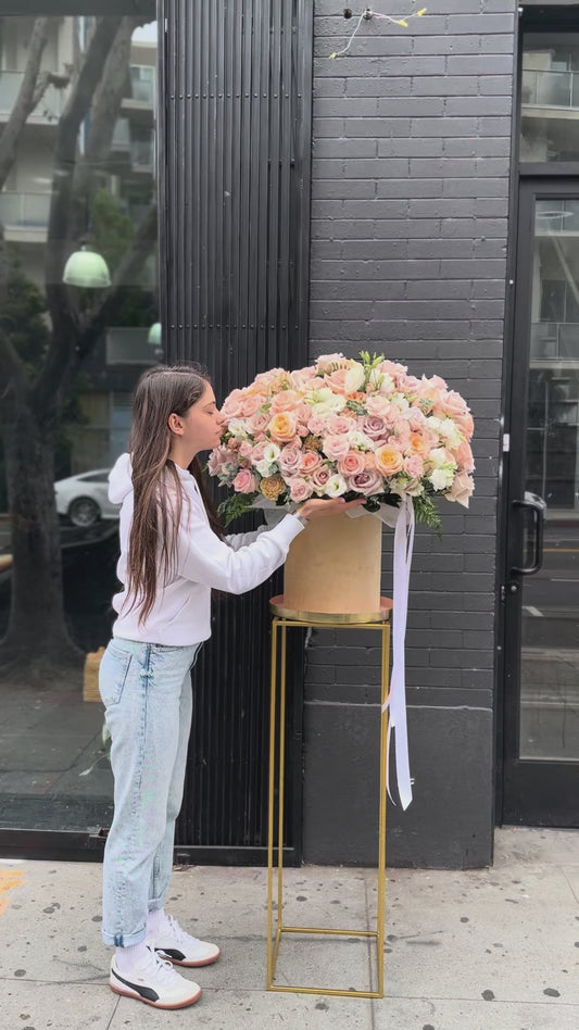 Soft pastel floral arrangement in warm peach and ivory tones, ideal for romantic occasions and special celebrations.