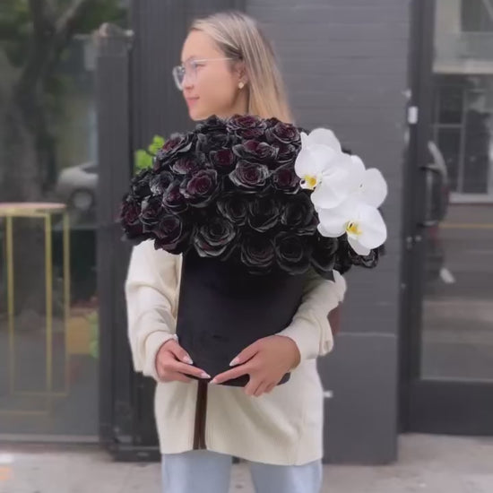 Luxury flower arrangement featuring dark velvet roses and exotic orchids, perfectly styled in a精致 gift box for special occasions.