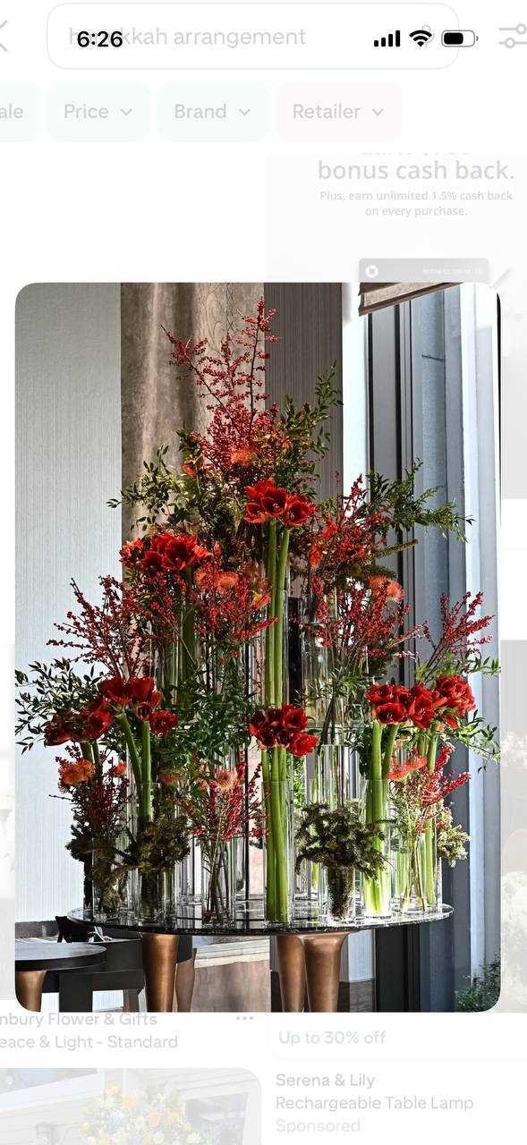 Tall red amaryllis Christmas and New Year statement arrangement in clear glass tubes with red ilex berries and branches for Los Angeles event delivery.