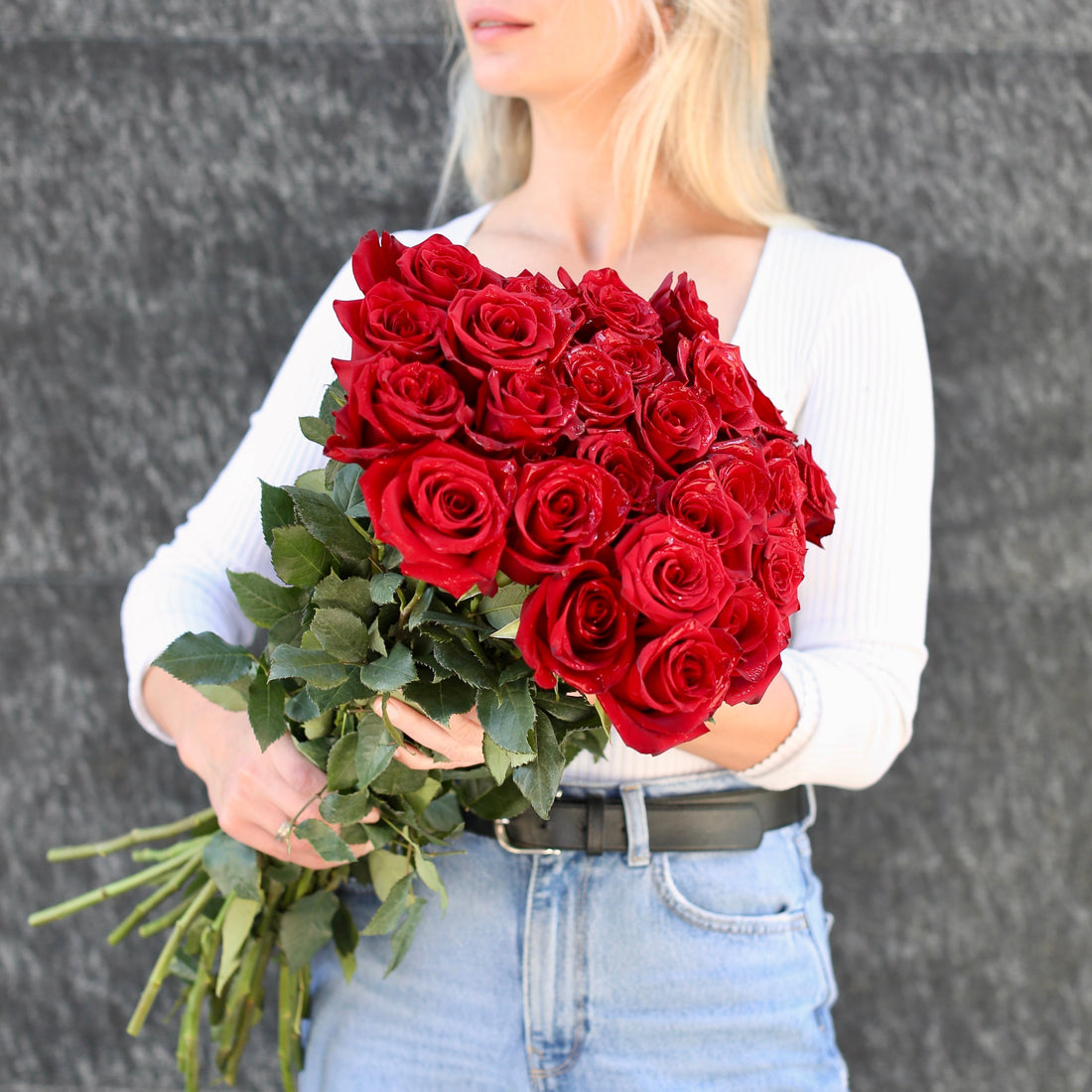 Romantic bouquet of red roses with lush green accents, ideal for expressing love
