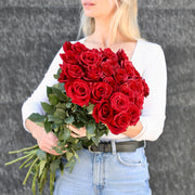 Romantic bouquet of red roses with lush green accents, ideal for expressing love