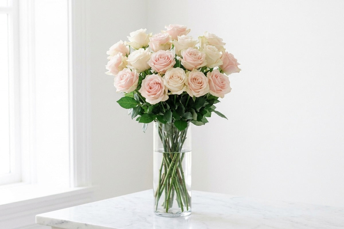 Tall blush rose bouquet in a glass vase on marble — same-day anniversary flowers Los Angeles