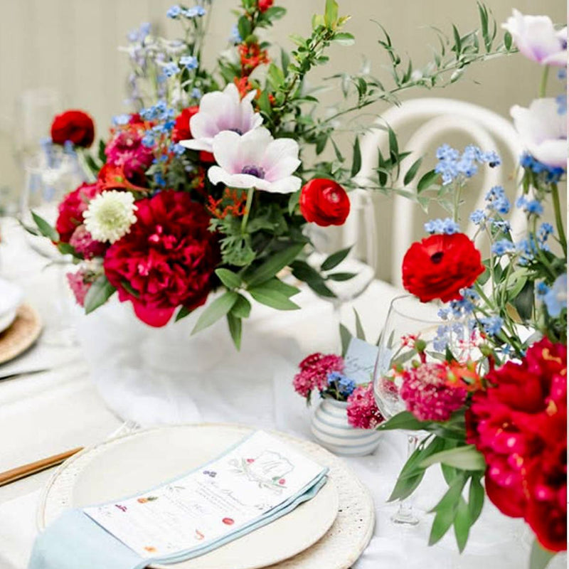 4th of July centerpiece with white anemones, red peonies, blue forget-me-nots, and red ranunculus in a white compote vase for Los Angeles delivery.
