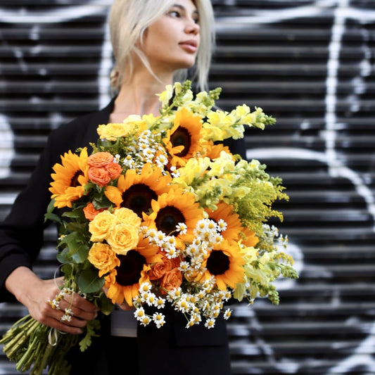 Vibrant sunflowers bouquet featuring daisies, roses and greenery in a joyful, colorful composition