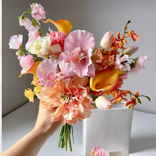 Tropical bridal bouquet with pink orchids, peach dahlias, mango calla lilies, and orange mokara orchids in Los Angeles