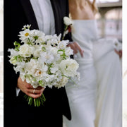White cosmos and lisianthus bridal bouquet held by groom at a Los Angeles wedding