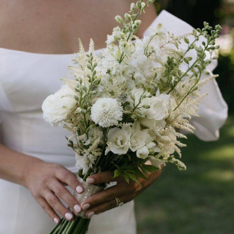 White meadow-style bridal bouquet with astilbe, delphinium, ranunculus, and scabiosa in Los Angeles