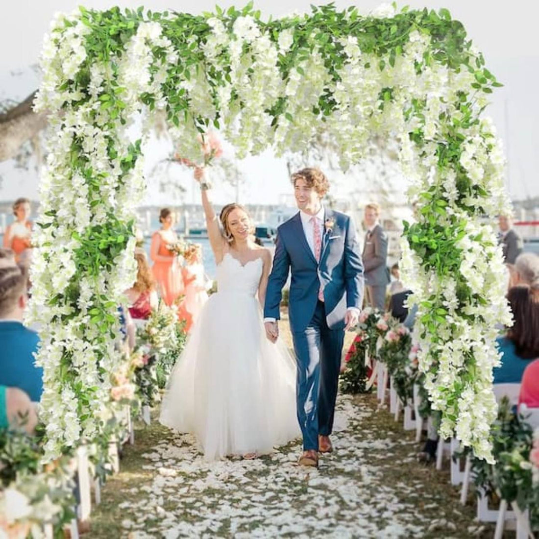 White wisteria wedding arch with cascading blooms and greenery at an outdoor ceremony in Los Angeles